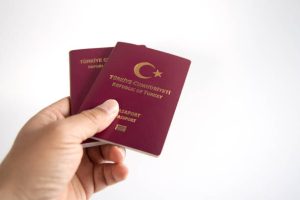 Turkish Passport and hand on white background. Copy Space.